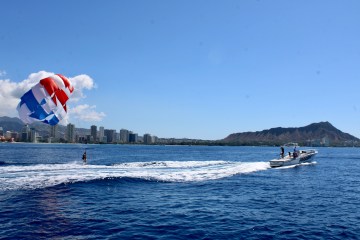 a man flying a kite in a large body of water